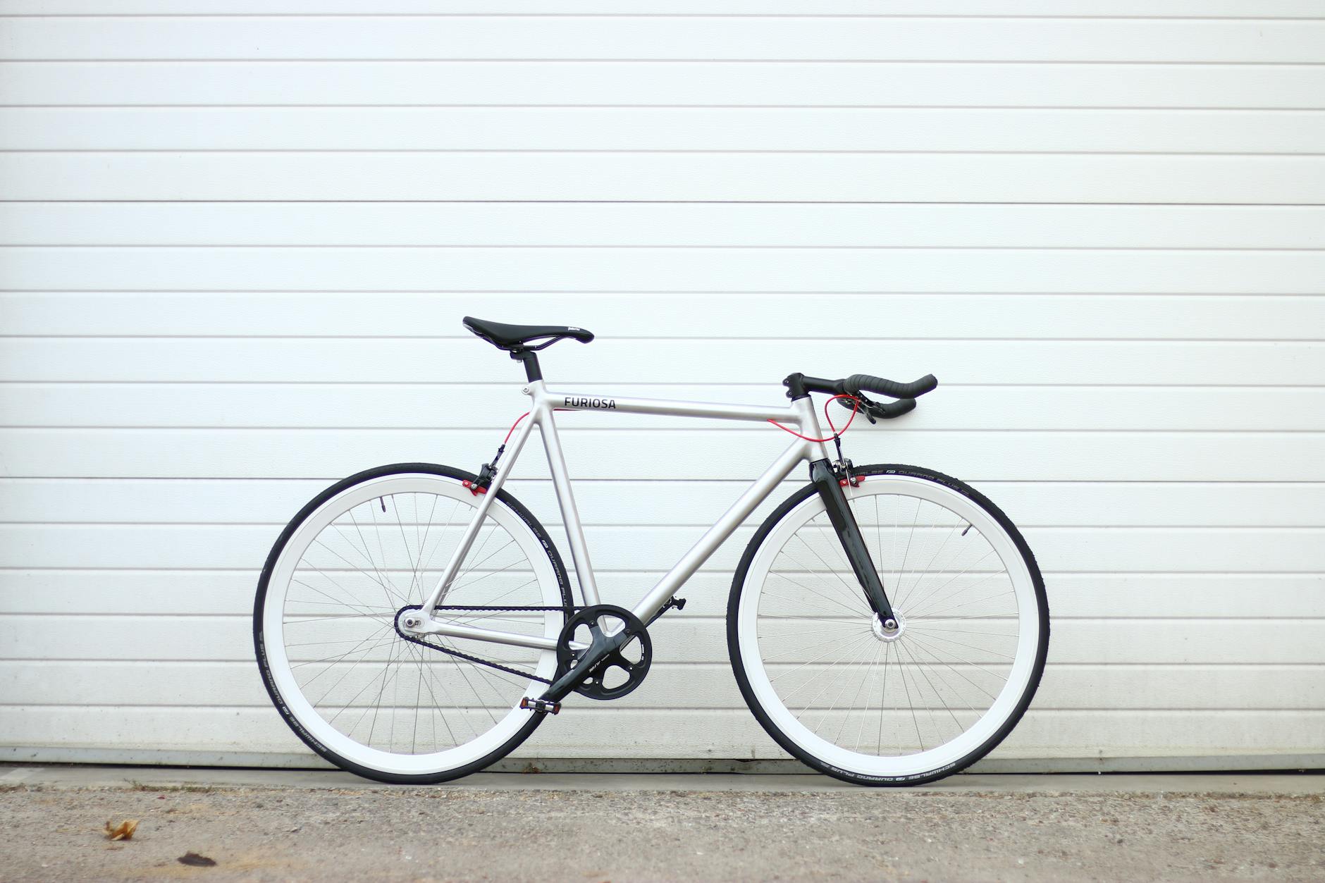 https://www.pexels.com/photo/a-silver-and-white-bicycle-parked-against-a-white-wall-28237097/